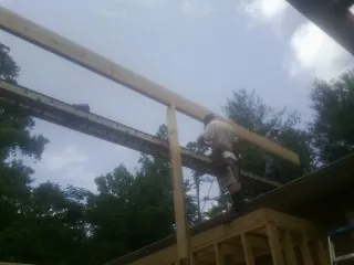 Carpenter setting a ridge beam over a new addition frame — Ice Dam Removal by Roofing Brothers in Bowling Green
